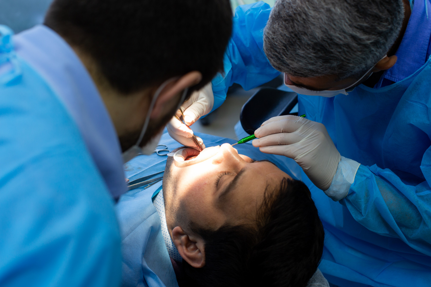 Хирург проводит удаление зуба мудрости в стоматологии HI-TECH Clinic